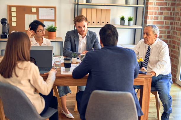 istock Group of business workers working together. Sitting on desk using laptop and talking at the office 1204808991