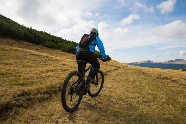 istock biker rides on rural road in summer 1204810470