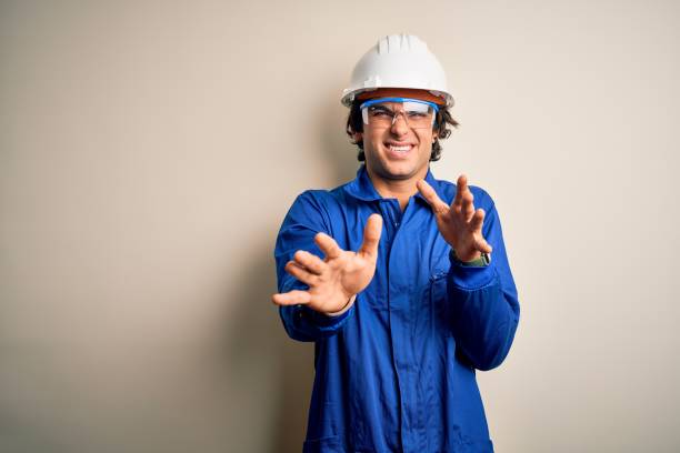 istock Young constructor man wearing uniform and security helmet over isolated white background disgusted expression, displeased and fearful doing disgust face because aversion reaction. With hands raised 1204811569