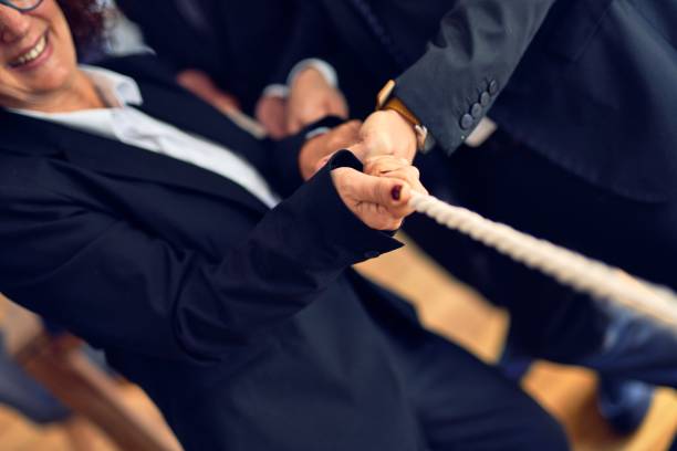 istock Business workers stretching rope at the office 1204811831