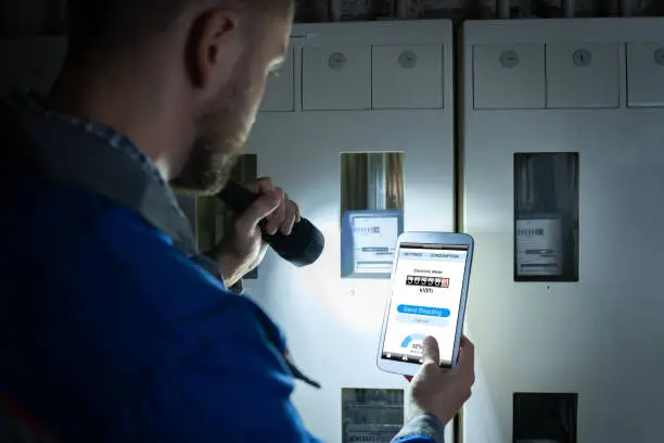 Photo of Man's Hand Holding Mobile Phone Showing Electric Meter Reading