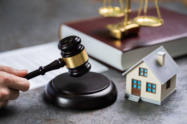 istock Judge With House Model Striking Mallet 1204813808