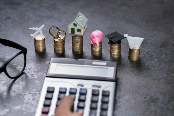 istock Man Calculating Expenses In Front Of Stacked Coins 1204813818
