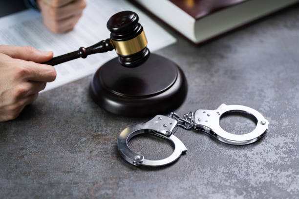 istock Judge Hand Striking Gavel With Handcuffs On Desk 1204813828