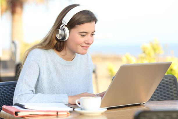 istock Student e-learning with headphones and laptop in a bar 1204815401