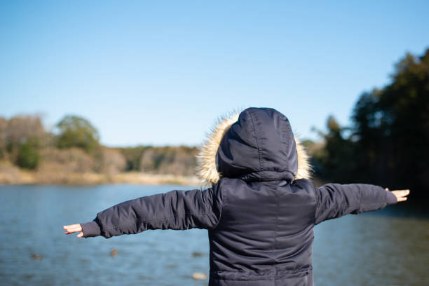 istock Girl with open arms by the pond 1204815567