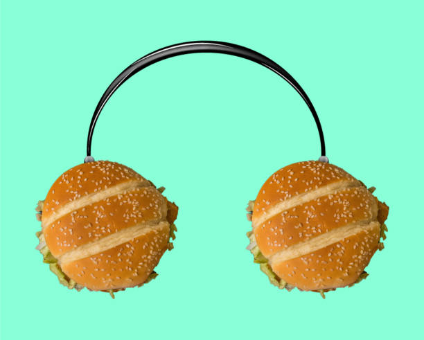 muzyka smakuje tak pysznie. słuchawki z burgerami jako dynamika na jasnoniebieskim tle. - turkey burger audio zdjęcia i obrazy z banku zdjęć