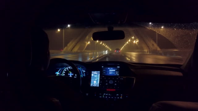 Chinese uber drives down highway in the rain at night.