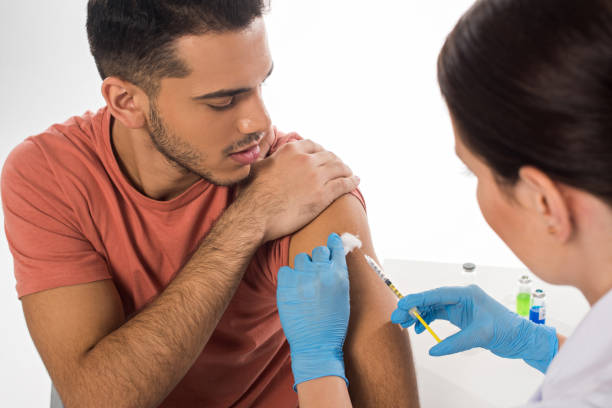 흰색에 고립 된 잘 생긴 환자에 주입을하고 의사의 선택적 초점 - syringe injecting vaccination cold and flu 뉴스 사진 이미지