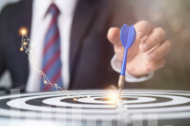 istock target and strategy concept, businessman focus to aim by throwing dart on targeting with finance graph growing up 1204831370