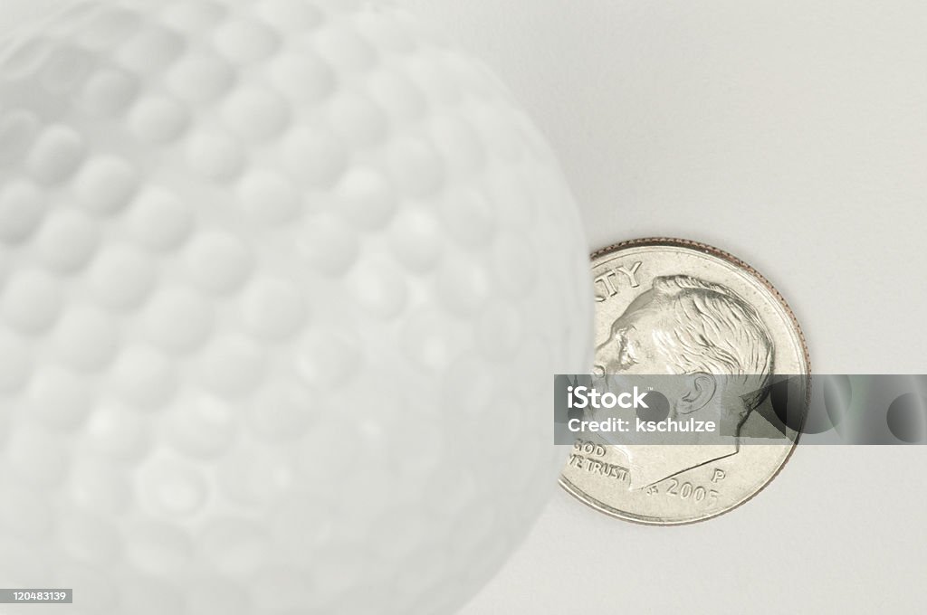 Dieci centesimi USA segni sulla lie di una pallina da golf - Foto stock royalty-free di Argentato