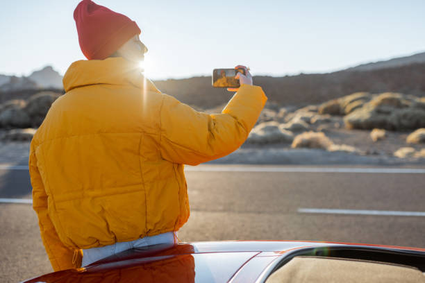 istock Woman enjoying roadtrip on a sunset 1204832566