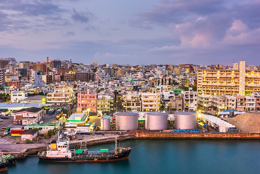 Naha, Okinawa, Japan industrial cityscape along Tomari Port at twilight.