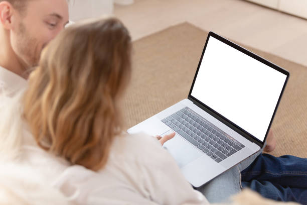 istock Young married couple using a laptop next to their beloved dog 1204836027