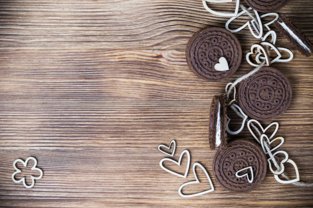 chocolate chip cookie sandwich on a wooden surface. hearts of wood strung on a rope. Happy Valentine's day. beautiful picture with biscuits. wooden background. texture. chocolate chip cookie sandwich on a wooden surface. hearts of wood strung on a rope. Happy Valentine's day. beautiful picture with biscuits. wooden background. texture. round sugar cookie stock pictures, royalty-free photos & images