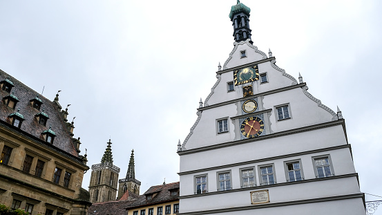 Rothenburg ob der Tauber, Bavaria, Germany - October 10, 2019: Standing on the market square and looking at the town hall, the St. James church and the Ratstrinkstube Clock tower.  This medieval town is part of the German Romantic Road.