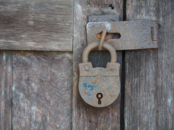 istock A rusty old padlock used to lock old wooden doors 1204839334