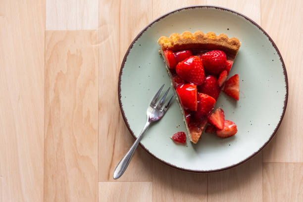 a piece of fresh strawberry cake on a decorative plate with view from above