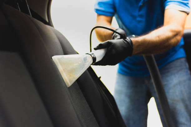 男は車の室内装飾洗浄を行う - 吸引方法との専門の化学洗浄。車両シートの衛生的な作業と汚れの除去 - car cleaning ストックフォトと画像