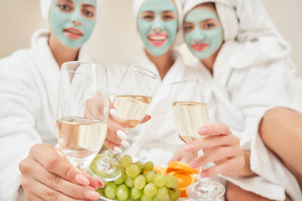 istock Female friends drinking wine in bed. 1204844378