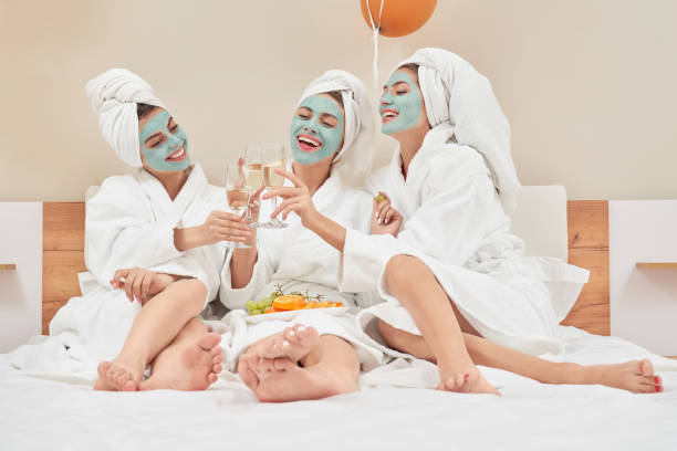 istock Female friends drinking wine in bed. 1204844383