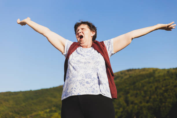 istock Senior woman holding both hands in the air 1204844419
