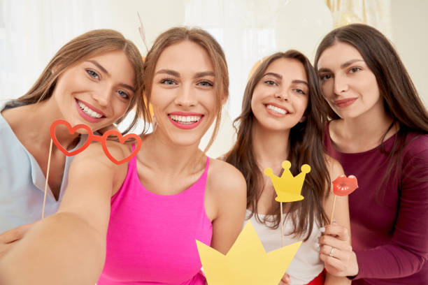istock Smiling girlfriends taking selfie, having party. 1204846789