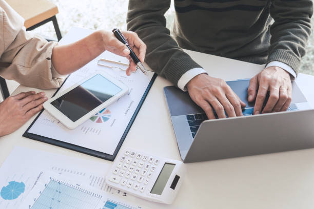 istock Midsection Of Businessman Discussing With Colleague While Using Laptop At Office 1204847071