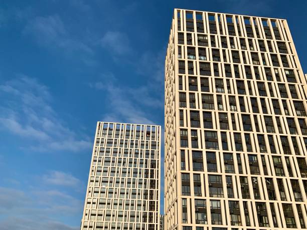 istock High-rise building on a background of blue sky. Tall new building with mirrored windows, bottom view. Background texture: office building. 1204847108
