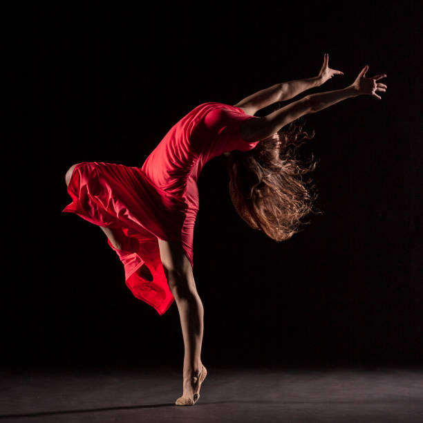 istock Dancer in red dress on black background 1204847212