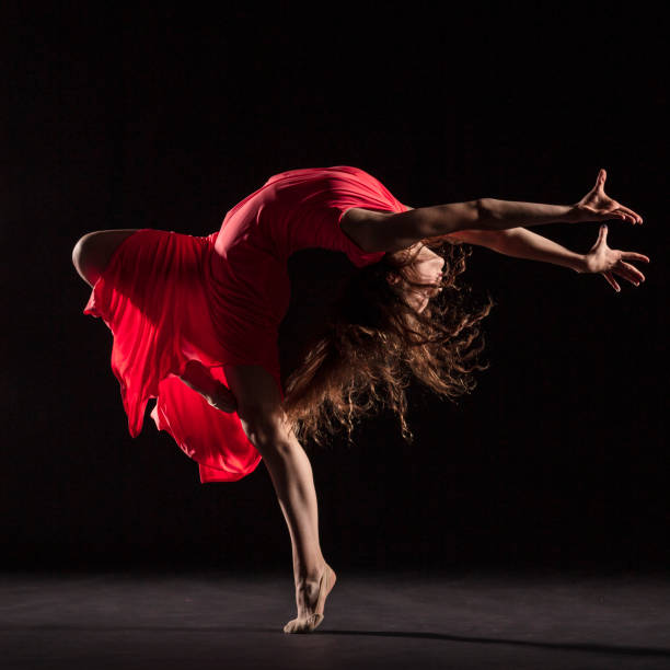 istock Dancer in red dress on black background 1204847217
