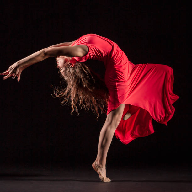 istock Dancer in red dress on black background 1204847273