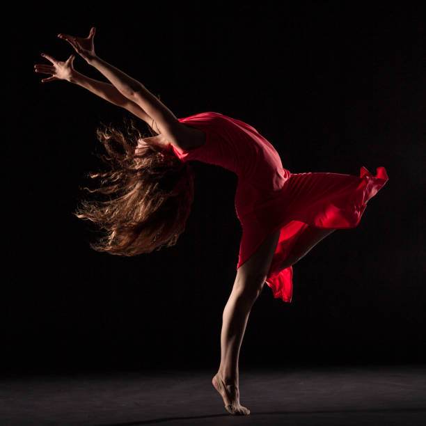 istock Dancer in red dress on black background 1204847277