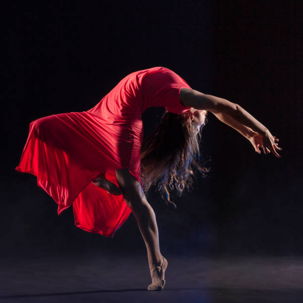 istock Dancer in red dress on black background 1204847313