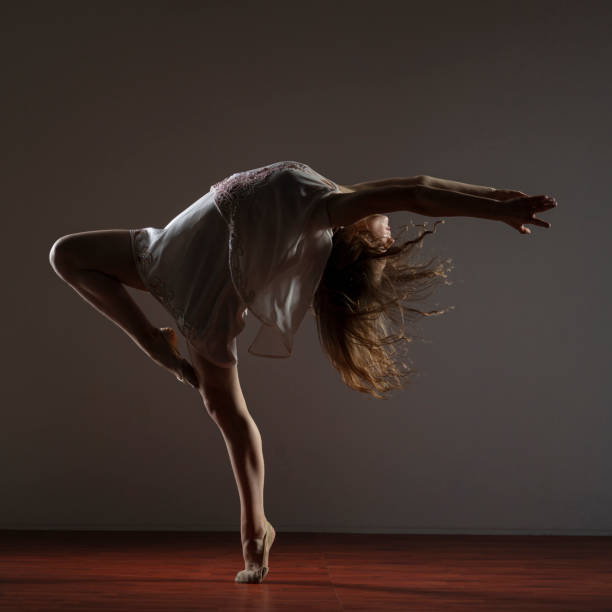 istock Dancer in white dress on dark background 1204847333