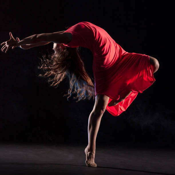istock Dancer in red dress on black background 1204847401