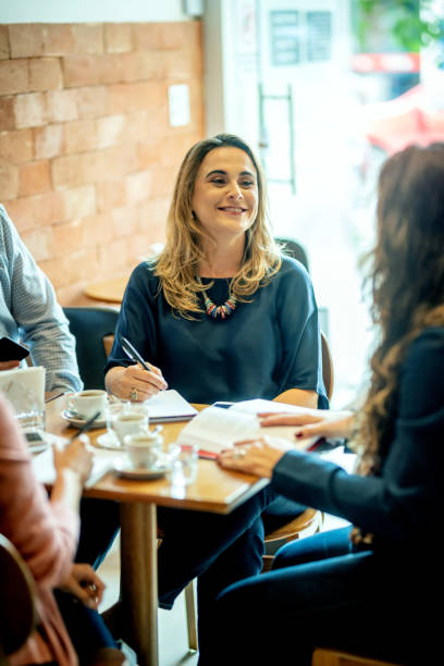 istock Woman drinking coffee in a coffee shop and talking 1204847797
