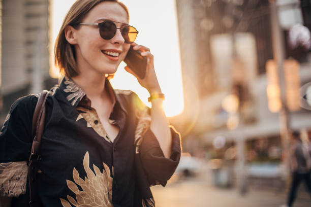 istock Cheerful young woman is talking on phone 1204852282