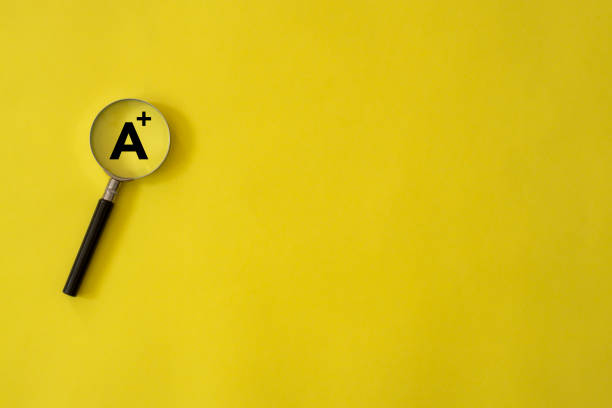 Grade - A+ on magnifying glass with copy space stock photo