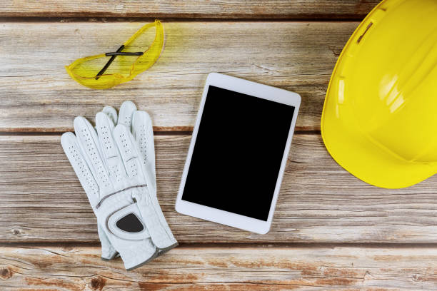 istock Construction and architecture in notepad of protective gloves, yellow hardhat 1204854834