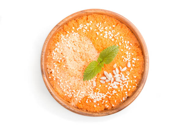 Carrot cream soup with sesame seeds in wooden bowl isolated on white background. top view, flat lay, close up.