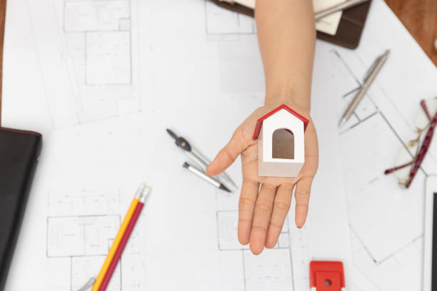 istock Directly Above Shot Of Architect Holding Model House Over Table 1204856102