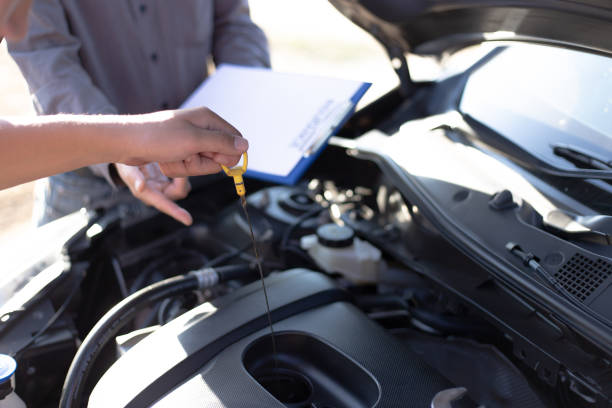 istock Cropped Hand Of Mechanic Using Dipstick In Car Engine 1204856245