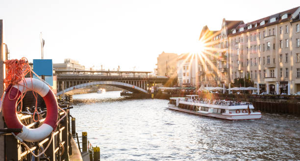 istock Sunset in Berlin - Panoramic angle of Friedrichstrasse railway station and bridge over Spree river - Urban travel concept around european capital cities - Warm contrast sunshine filter 1204857824