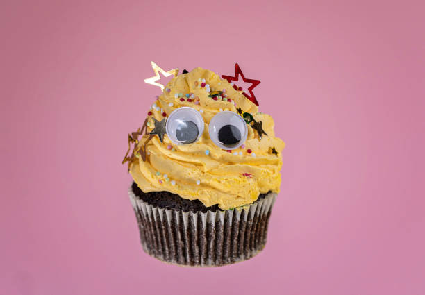 gelber muffin mit sprinklern in form von stern - back to front ideas surrealism concepts stock-fotos und bilder