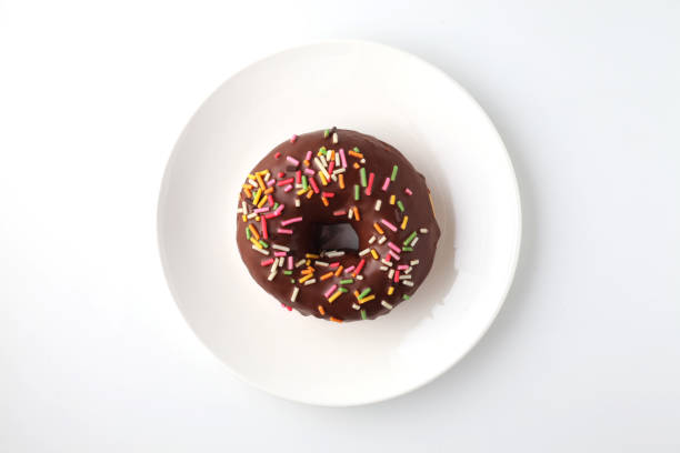 chocolate frosted doughnut on plate isolated on white background