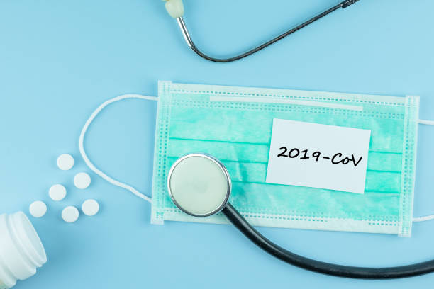 istock Protective face mask, Medicine pills and Stethoscope on blue background, against Novel coronavirus (2019-nCoV) or COVID-19 and Influenza. Hygiene, Health Insurance and Healthcare concept 1204865376