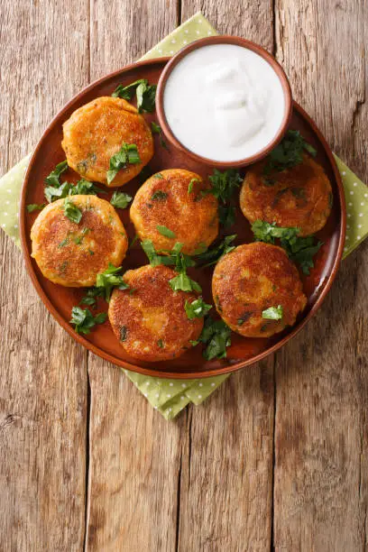 Aloo tikki is a popular Snack across India made using mashed potatoes close-up in a plate on the table. Vertical top view from above