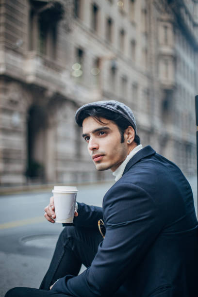 istock Stylish guy is drinking coffee on the street 1204868294