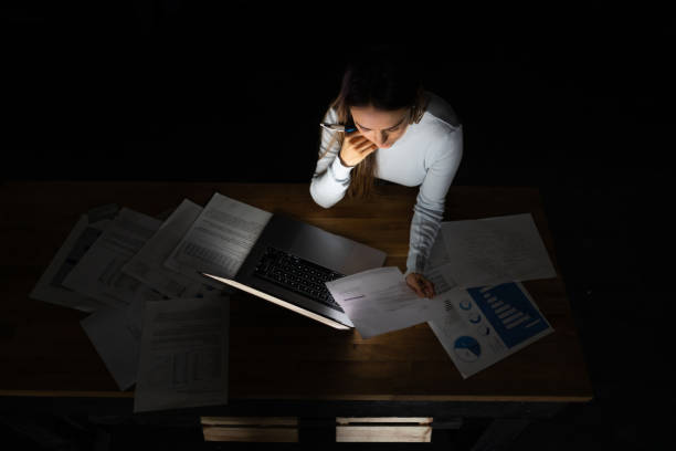 istock Business woman working from home late at night looking at documents and using laptop 1204868334
